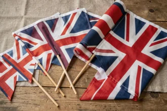 Collection de drapeaux du Royaume-Uni de différentes tailles disposés sur une table en bois rustique
